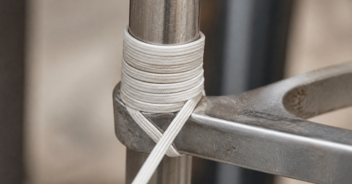Elastique blanc enroule autour cylindre metallique ferme