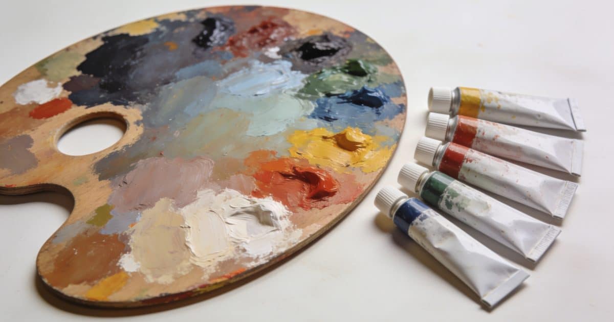 Palette de peinture avec tubes de couleur mélangés ensemble