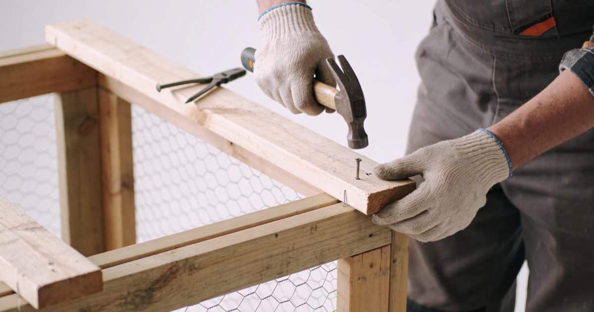 Personne construisant une structure en bois pour poules