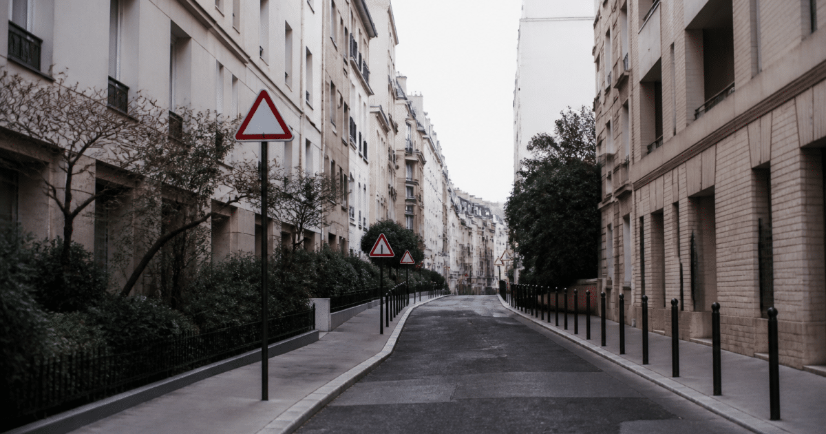 Rue urbaine avec immeubles résidentiels et panneaux d'avertissement visibles