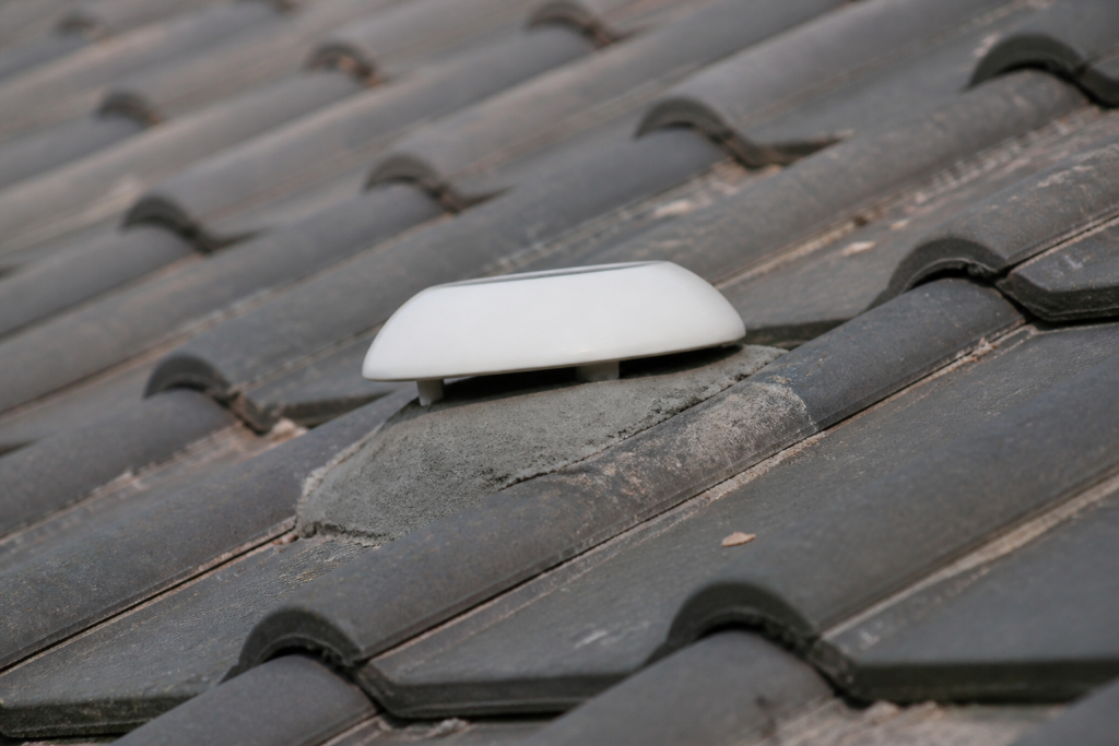 Tuiles grises scellees au mortier avec chapeau ventilation blanc