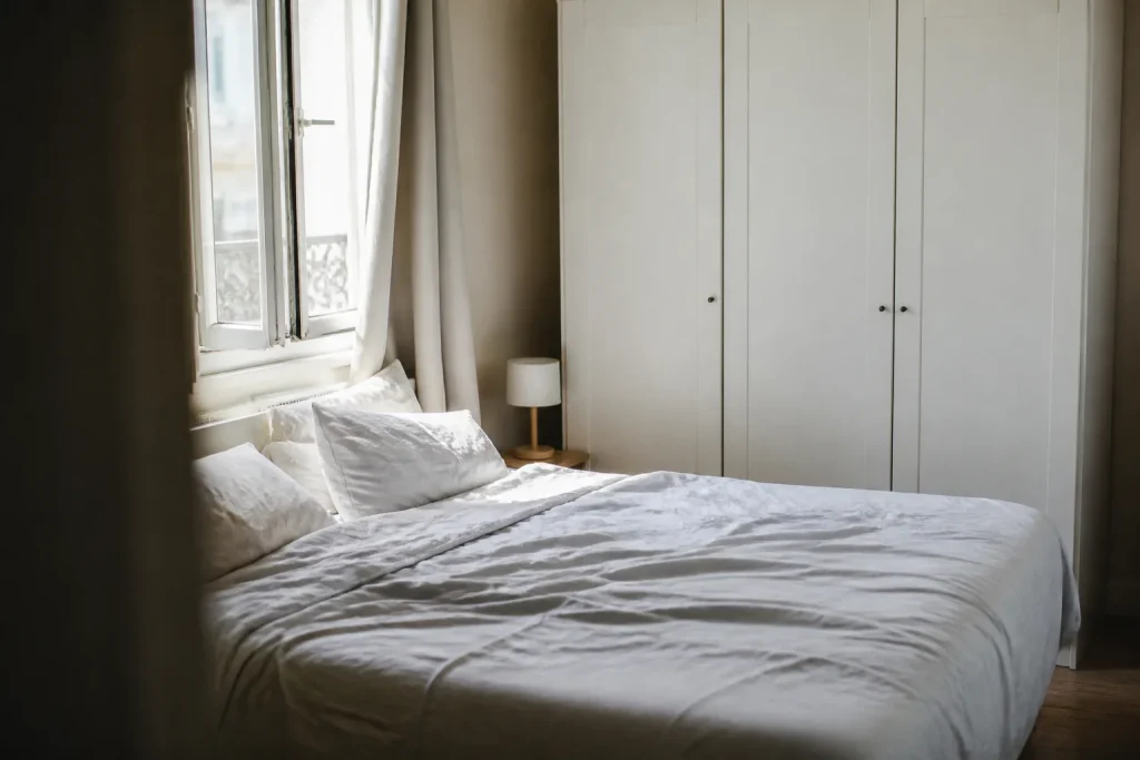 Lit double pres de la fenetre et armoire blanche