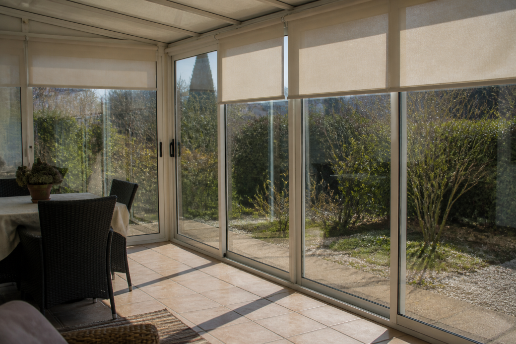 Veranda lumineuse avec stores enroules et vitres propres