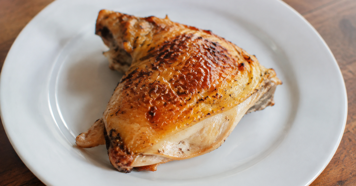 Morceau de volaille dore pose sur assiette blanche